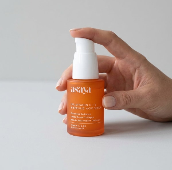 World of Asaya 15% Vitamin C + E Serum with Ferulic Acid to Reduce Dark Spots & Hyperpigmentation held in hand, candid photo