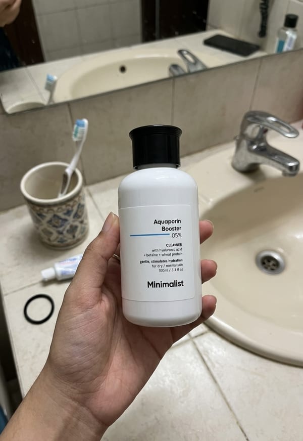 Minimalist Aquaporin Booster 5% Cleanser held in hand, candid photo
