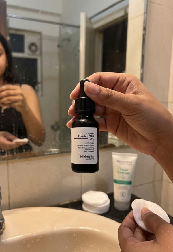 Minimalist Copper Peptide + PDRN 1.25% Face Serum held in hand, candid photo