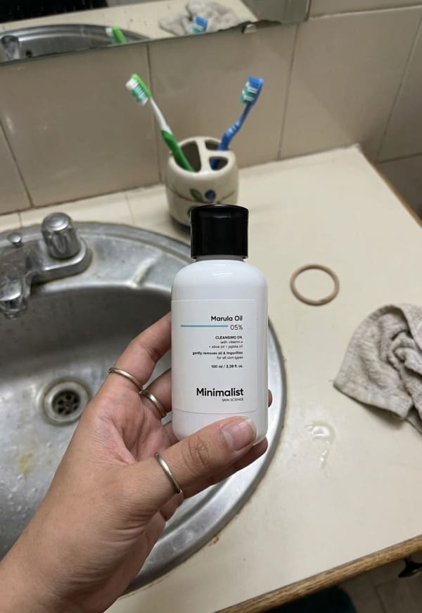 Minimalist Marula Oil 05% Cleansing Oil held in hand, candid photo