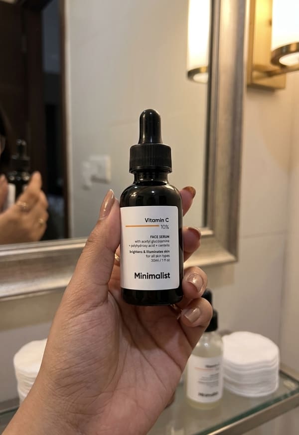 Minimalist Vitamin C 10% Face Serum held in hand, candid photo