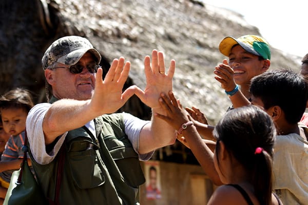 Guy high-fiving some kids