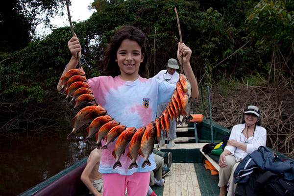 kid holding up piranha catch