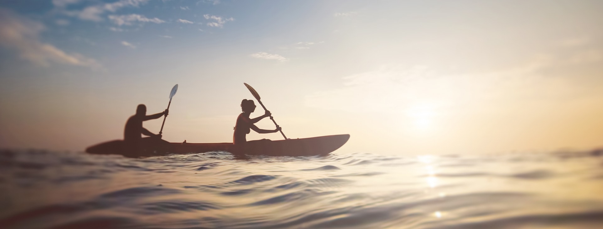 People on sea kayak at sunset