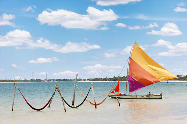 hammocks over the water with boat