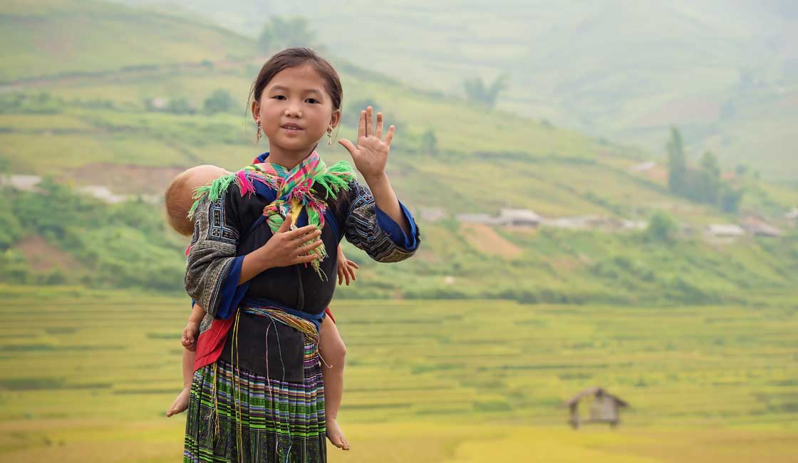 Hmong girl dragende een slapende peuter