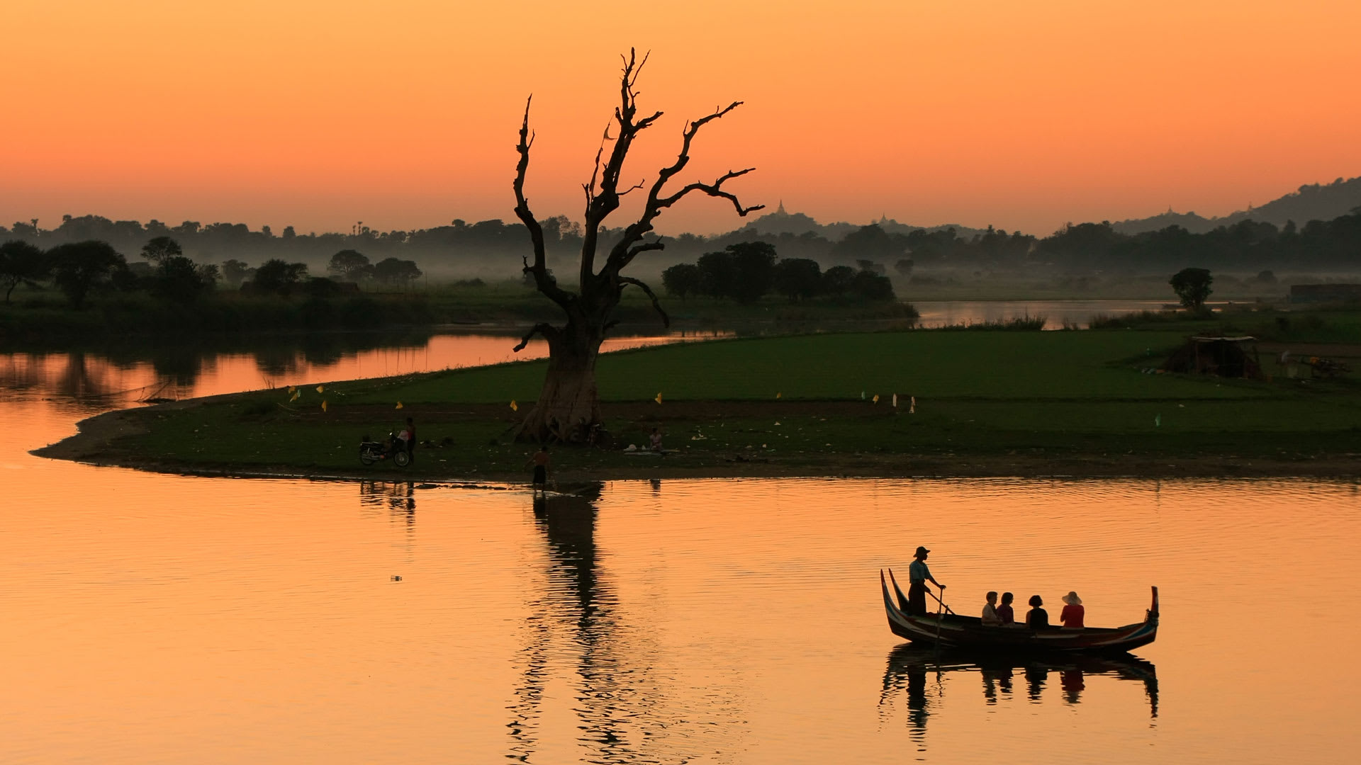 Local fishing boat on the Irrawaddy river at sunset