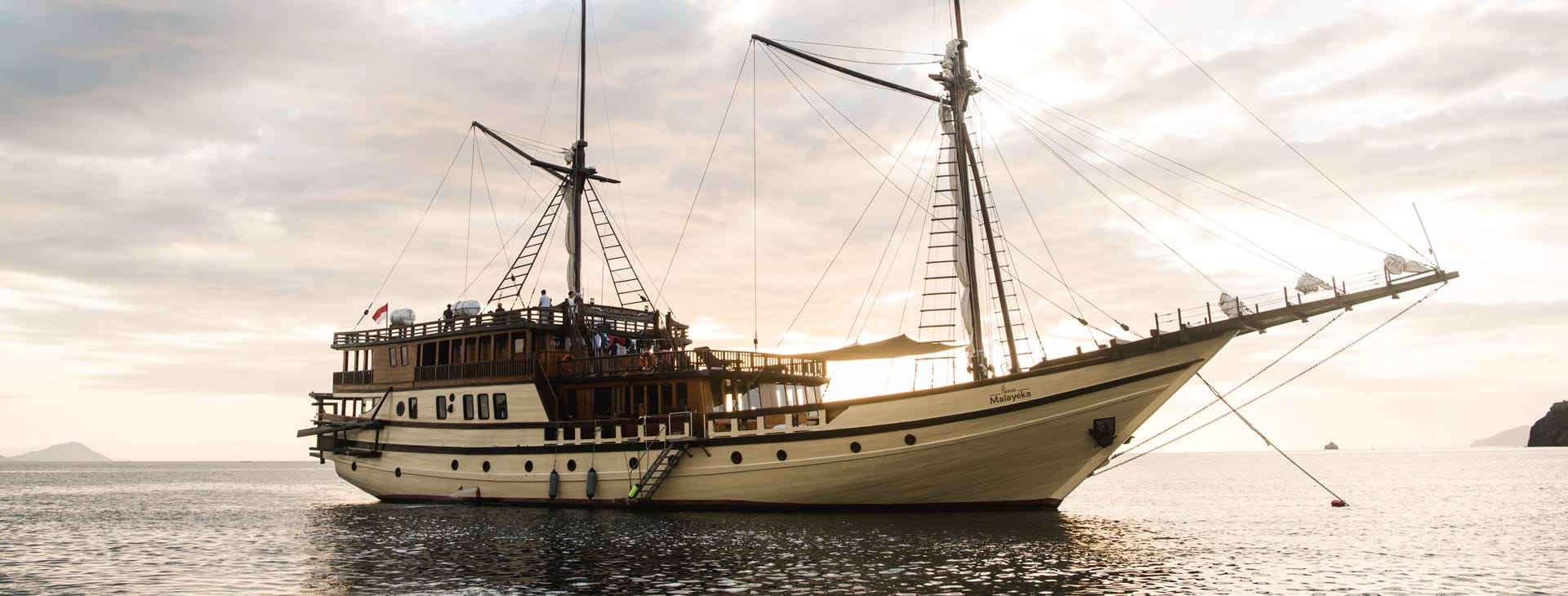 Wooden mast yacht at anchor