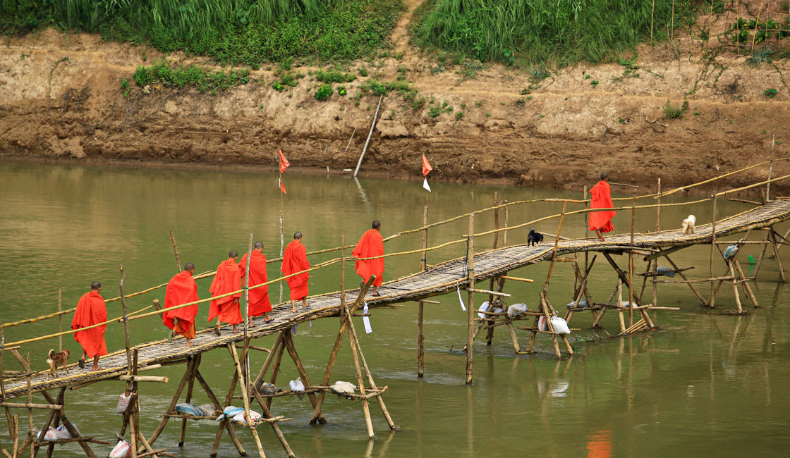 monks walking on a bridge