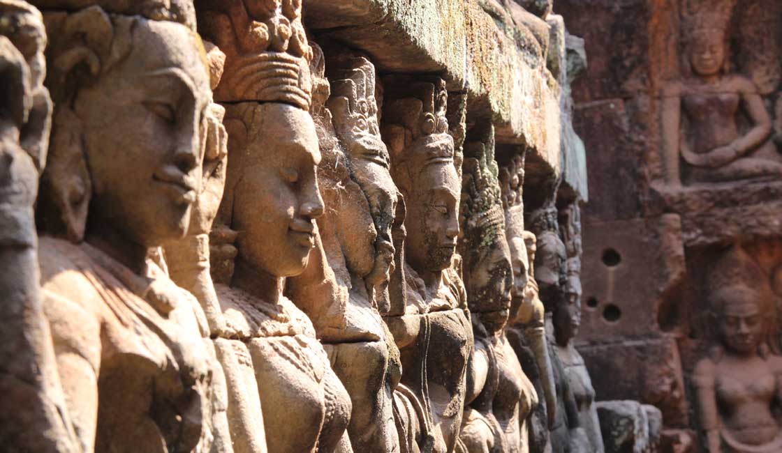 Closeup of stone carvings of Apsaras in Angkor temple