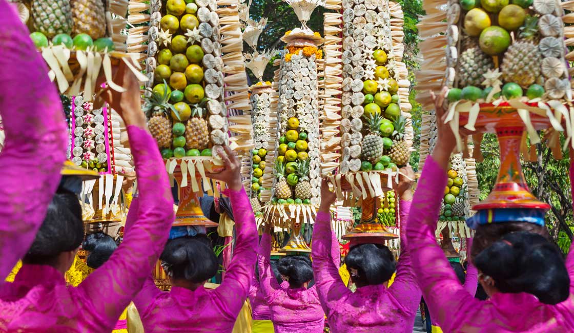 Ladies carrying tall fruit baskets