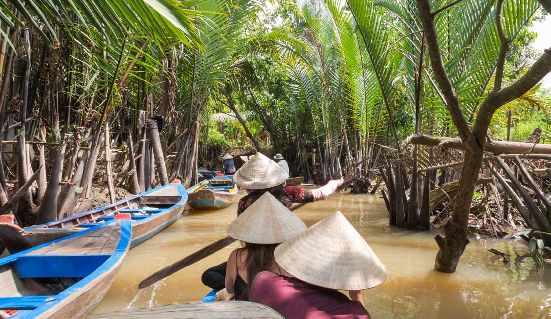 People canoing in narrow jungle cannals