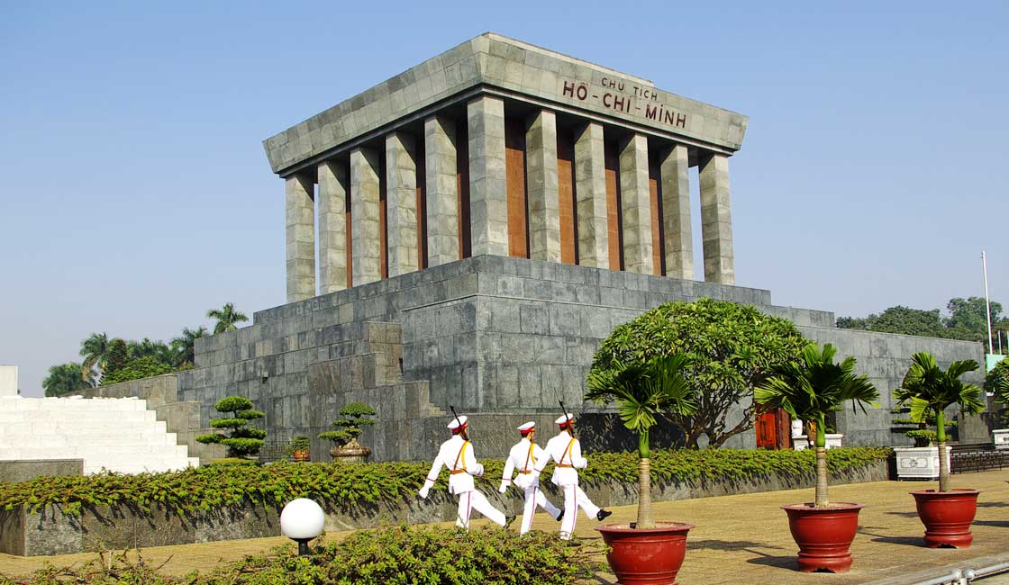 Guards marching in fron to a large mausoleum