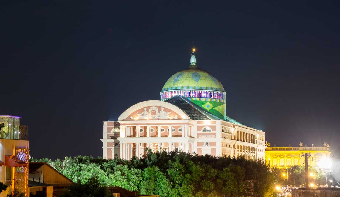 Large theatre building lit up at night 