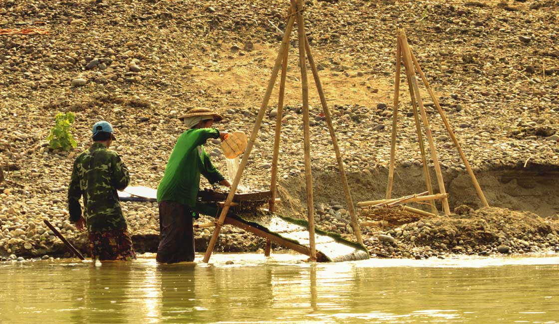 Two fishemen building a fish trap