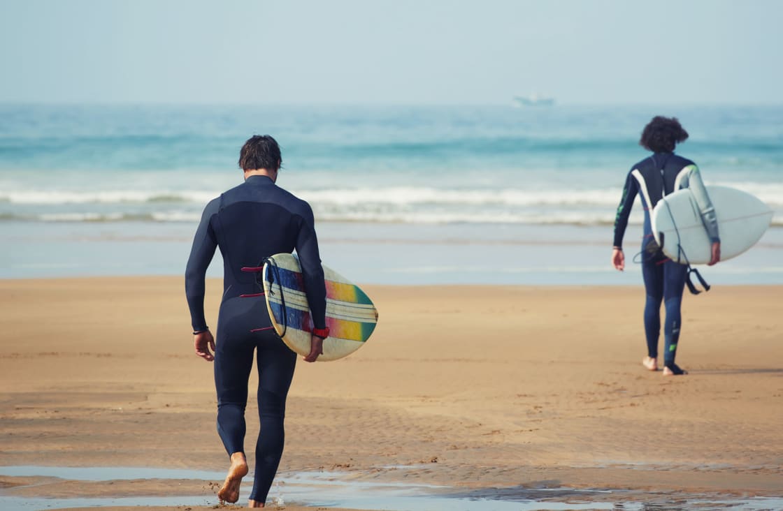 surfers walking towards the sea