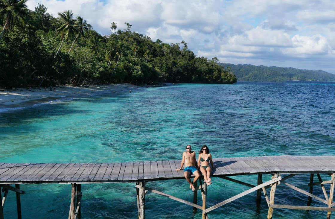 couple taking a sun bath in raja ampat