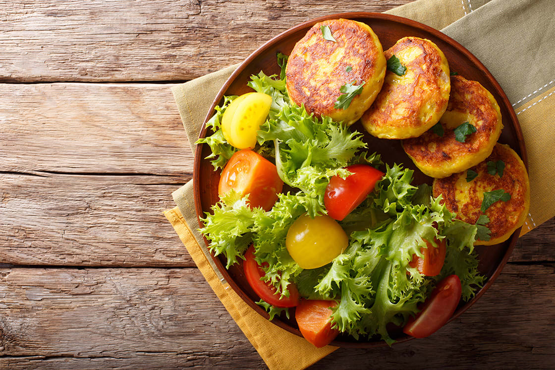 Freshly Prepared Potato Pancakes Are Served With Fresh Salad Close-up