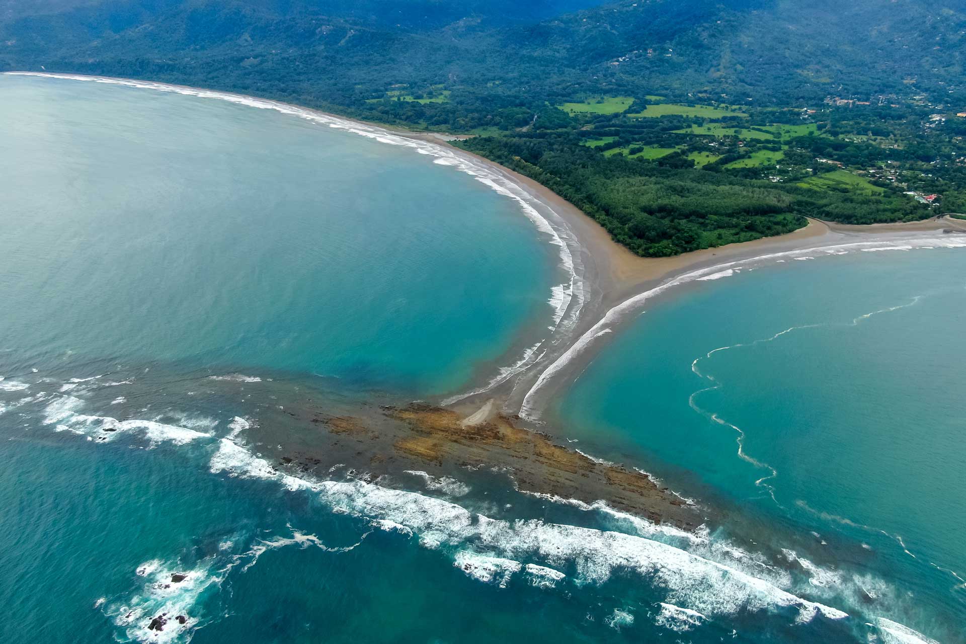 Aerial view of a large sandbar in the shape of a whale's tail at Marino Ballena National Park.