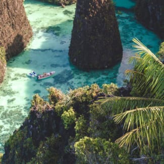 Small boat among karst formations of Raja Ampat