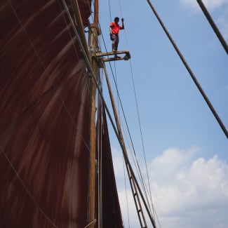 Large sail and a sailor on he mast