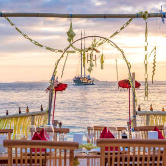 Table on the beach and a ship in the distance