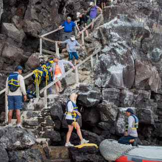 People walking down the stairs on the rocky hill