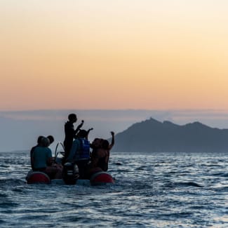 People on a zadiac at sunset