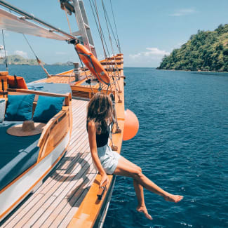 Young woman sitting on the side of the yacht