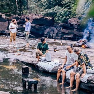 Friends hanging out with drinks by the waterfall