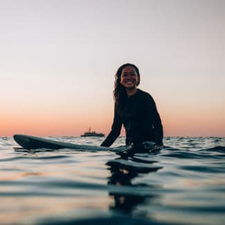 Woman sitting on a surfboard