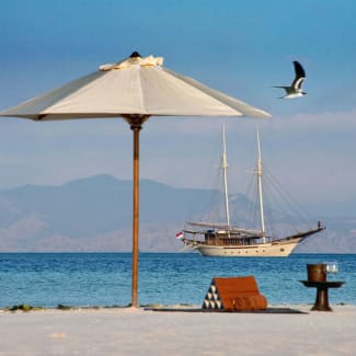 Umbrella on the beach and a ship in the beackround