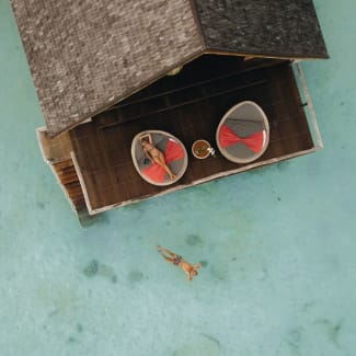 Aerial view of a couple on a terrace pf over the water villa