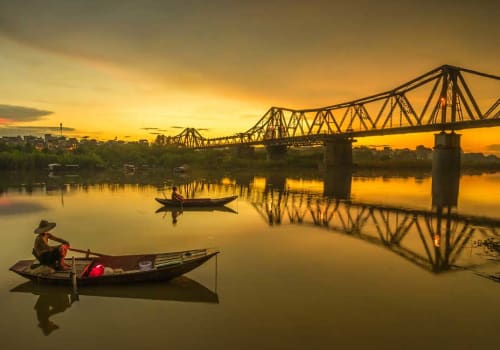 Small fishing boat at sunset near the bridge