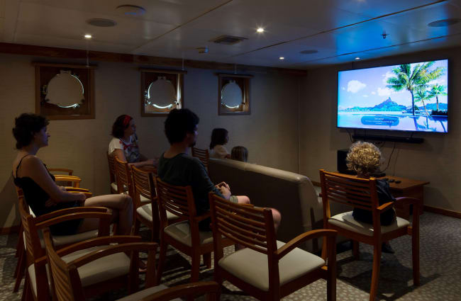 Passengers watching a movie in the auditorium room