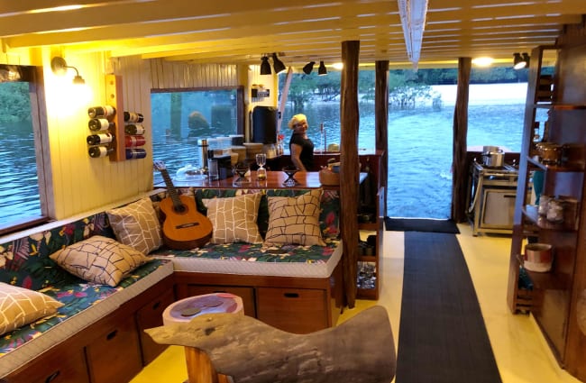 A living room with sofas, a guitar, and books