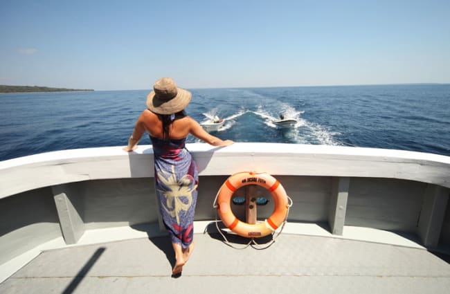 A woman standing on a rear of the boat