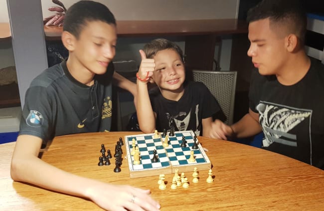 Family playing chess by the table