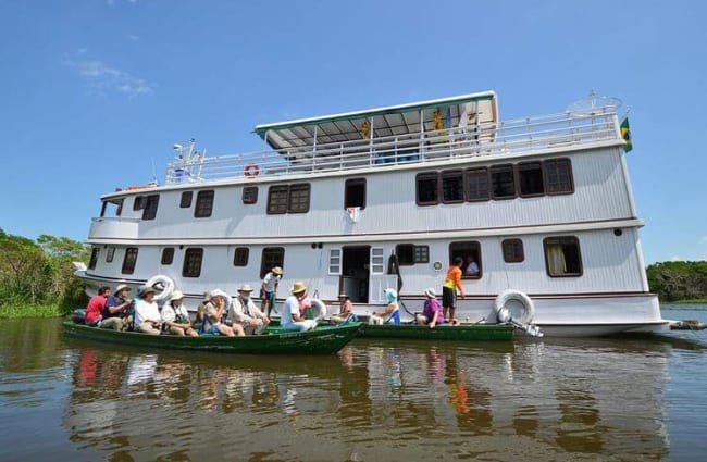 People in canoes by the ship