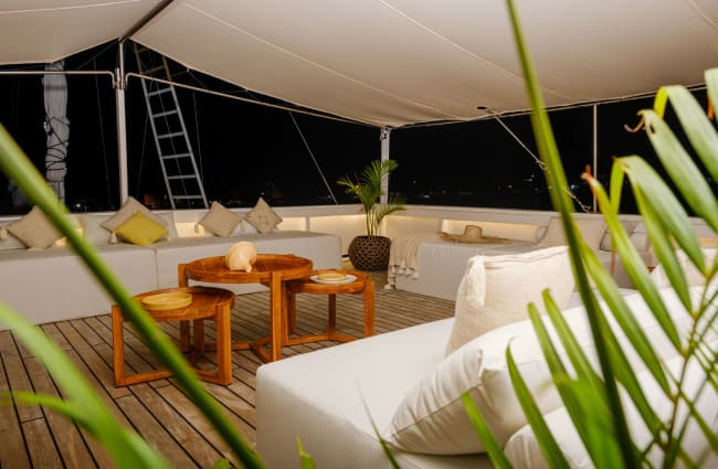 Table and sitting area on the open deck at night