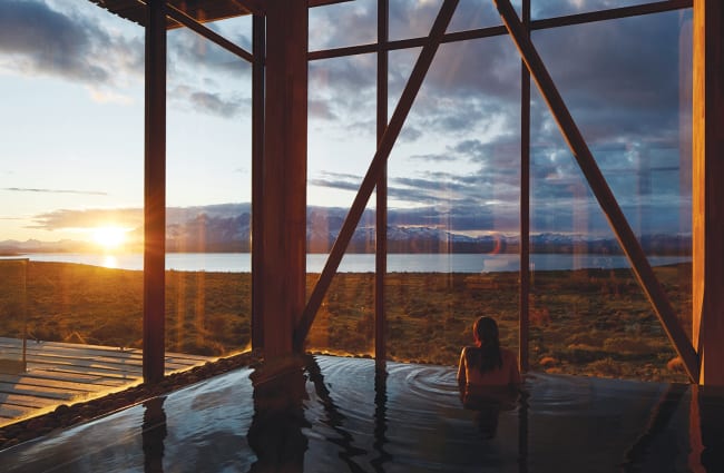 woman in a pool looking at the sunset