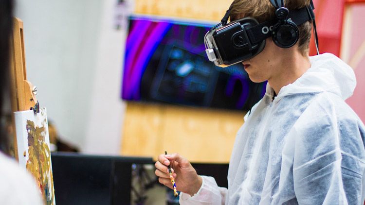 Young man painting using Virtual Reality headgear.