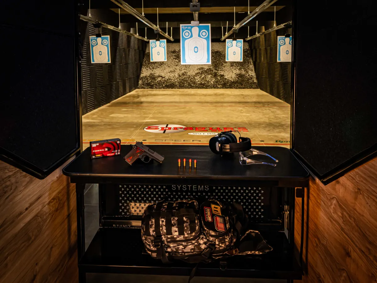 Indoor shooting range with targets and safety equipment staged at a lane