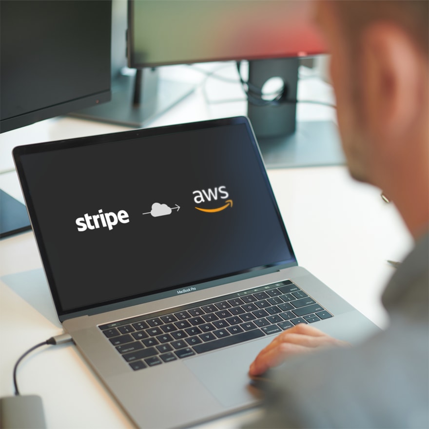 a laptop with its screen showing an arrow through a cloud from Stripe to Amazon Web Service