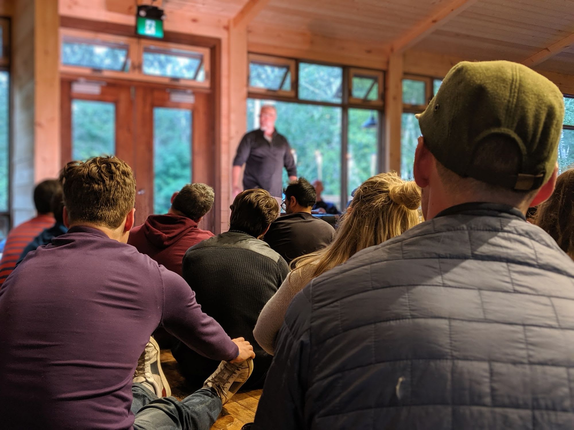 A crowd sitting on the floor focused