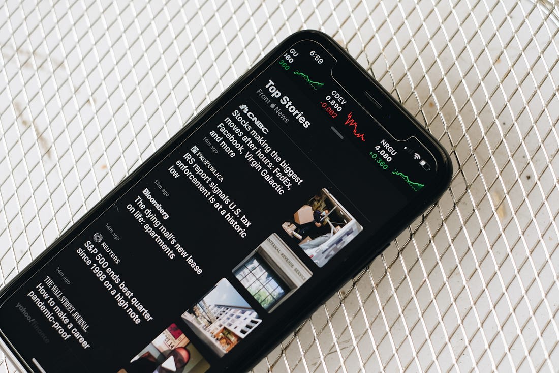 mobile phone with a news site homepage on the screen