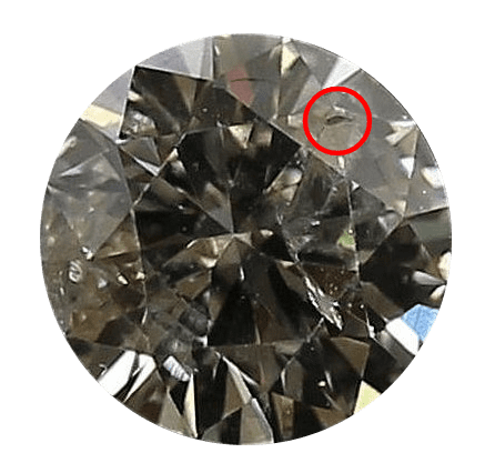 Image of a brown tinted diamond with a large cavity circled in red 