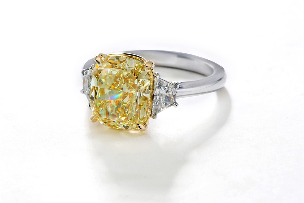 Yellow cushion cut diamond with white trapezoid side stones 