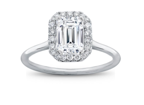 An emerald cut diamond ring with a halo in white metal 