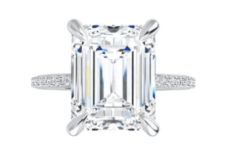 Emerald cut diamond in a prong setting with a pave band 